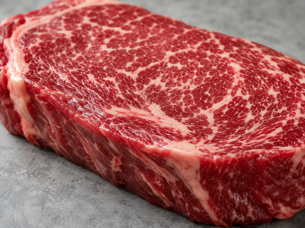 Close-up of raw steak showing the fine fat flecks that set a beef marble score