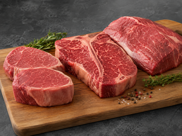 Raw premium Australian beef cuts arranged on a clean timber board