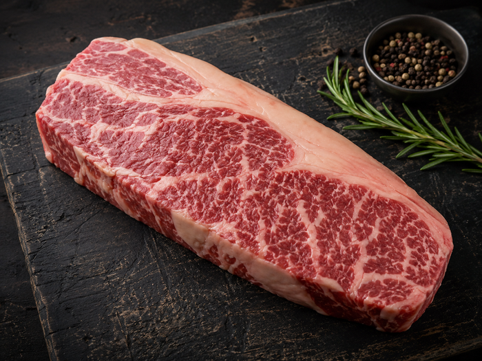 Raw scotch fillet steak showing rich marbling through the rib eye
